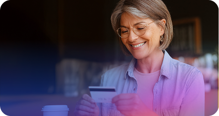 A lady holding her credit card smiling